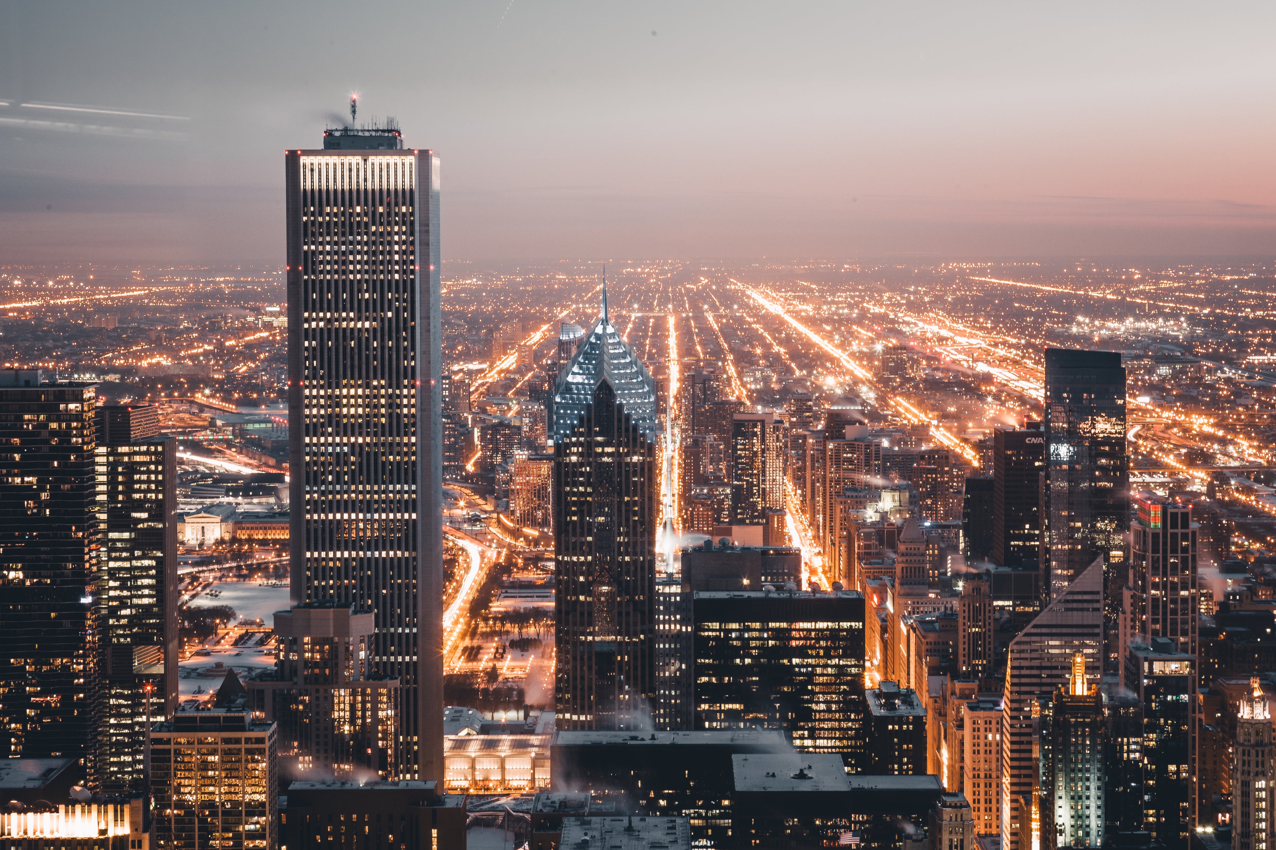 City skyline at dusk representing commercial buildings that benefit from professional lightning protection and grounding by Lightning Safety Solutions.