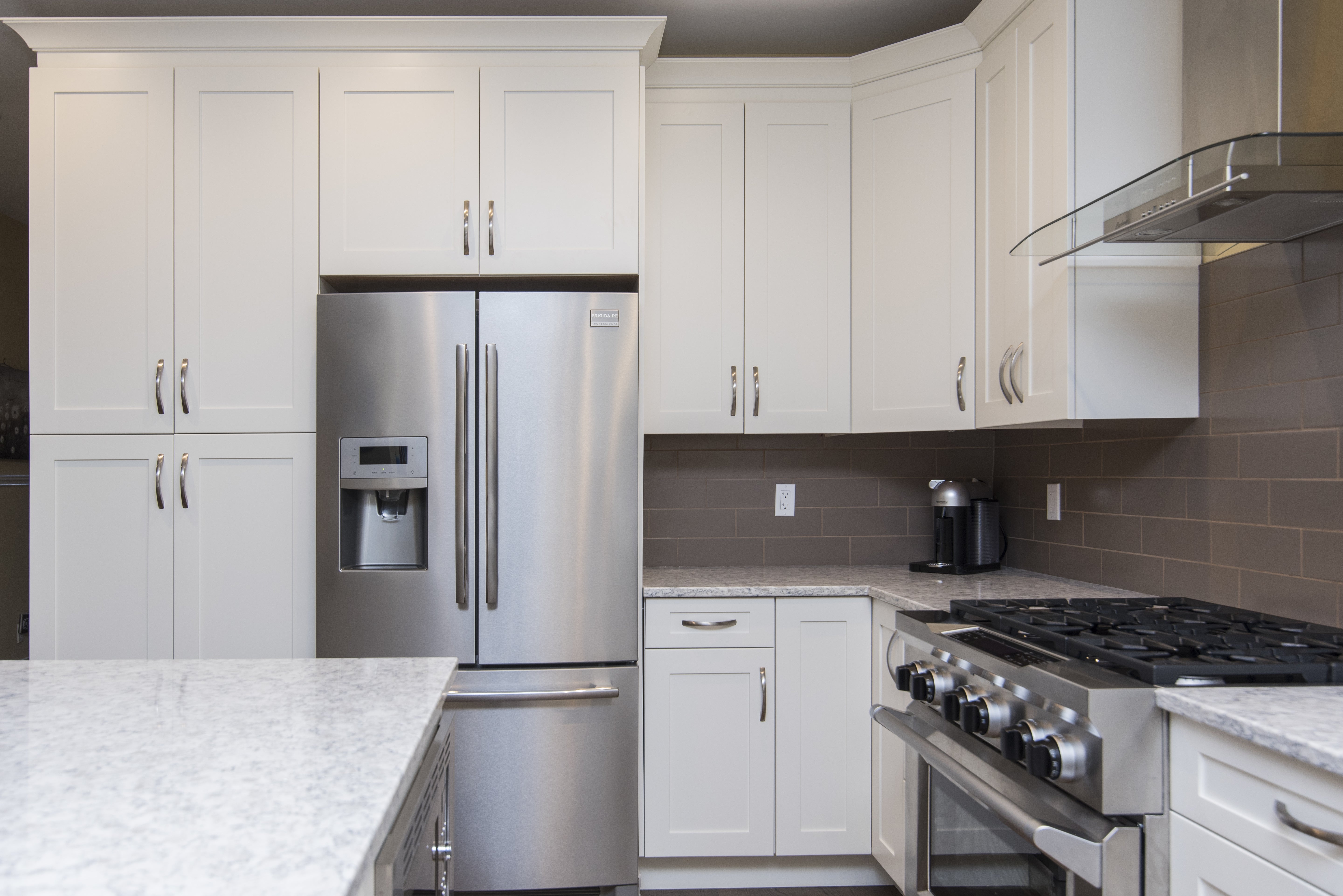 Modern kitchen with refrigerator, stove, and appliances that benefit from whole-home surge protection installed by Lightning Safety Solutions.